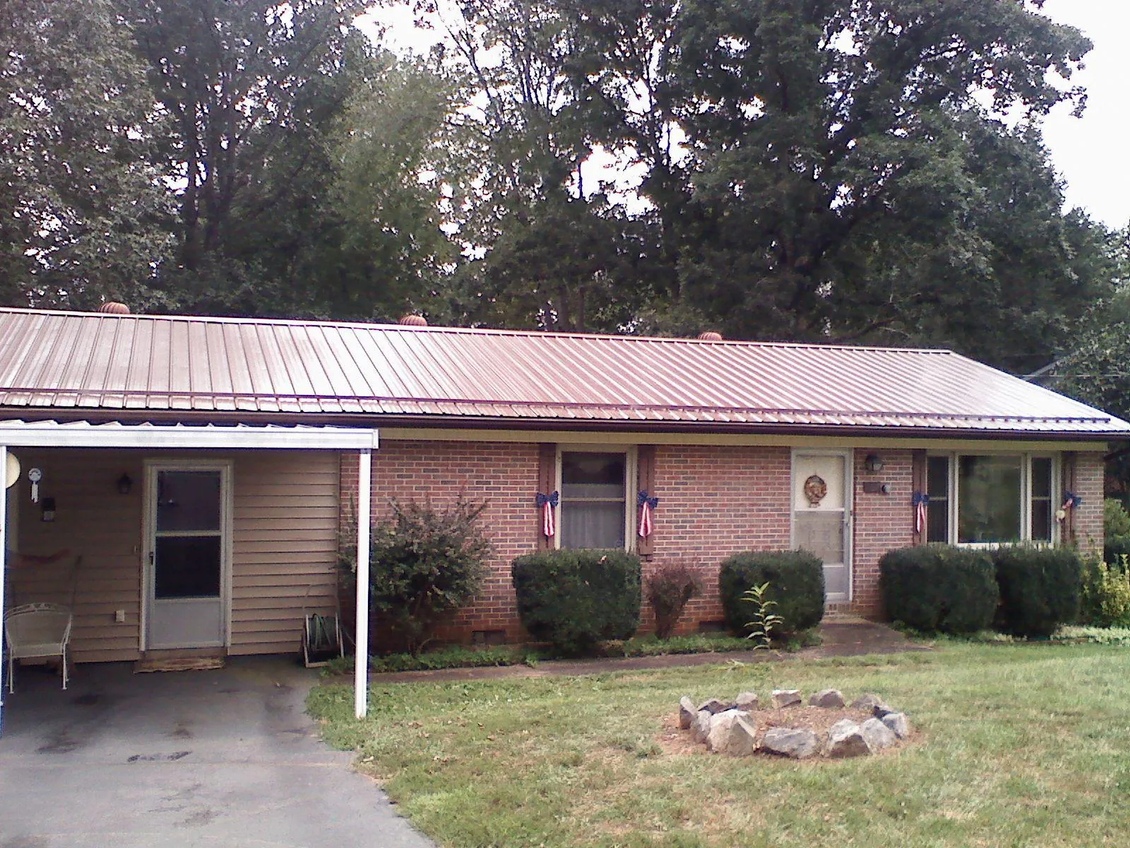 Bronze metal roof and carport on a brick ranch home — Roof Repair work by our crew in Phillipsburg